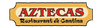 A rectangular restaurant sign with a tan border and cream center panel, featuring the word 'AZTECAS' in large red letters and 'Restaurant de Cantina' in black script below.