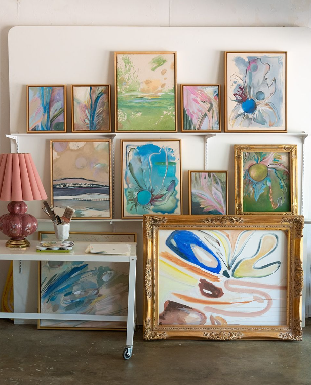 collection of Caitlin Shirock paintings in gold frames on display shelves