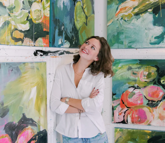 headshot of Maddie Maierhofer surrounded by her paintings