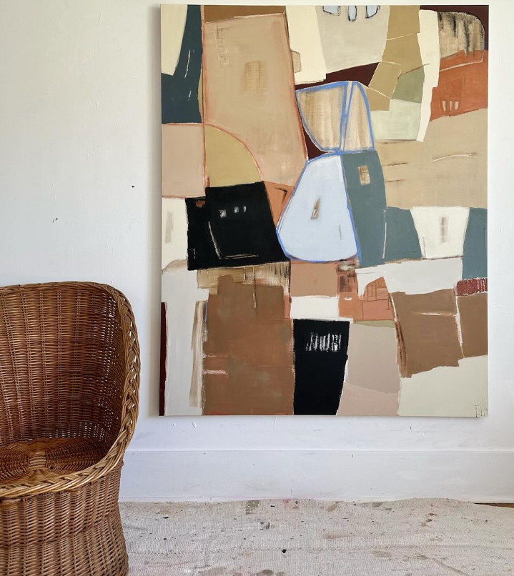 painting by sarah ella cole next to wicker chair