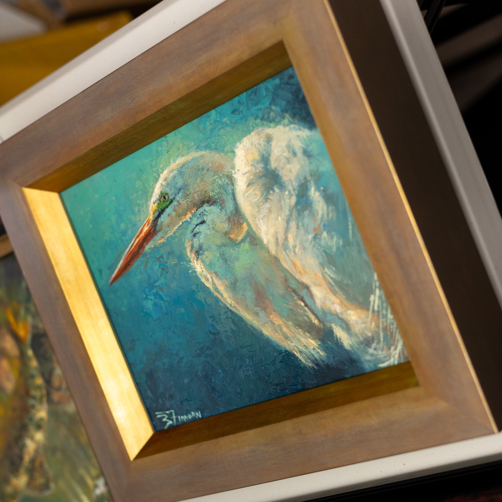 Framed painting of a heron on a blue background