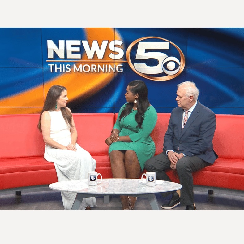 Three people sitting on a red couch in a news studio with 'NEWS THIS MORNING' and '5' logo in the background.