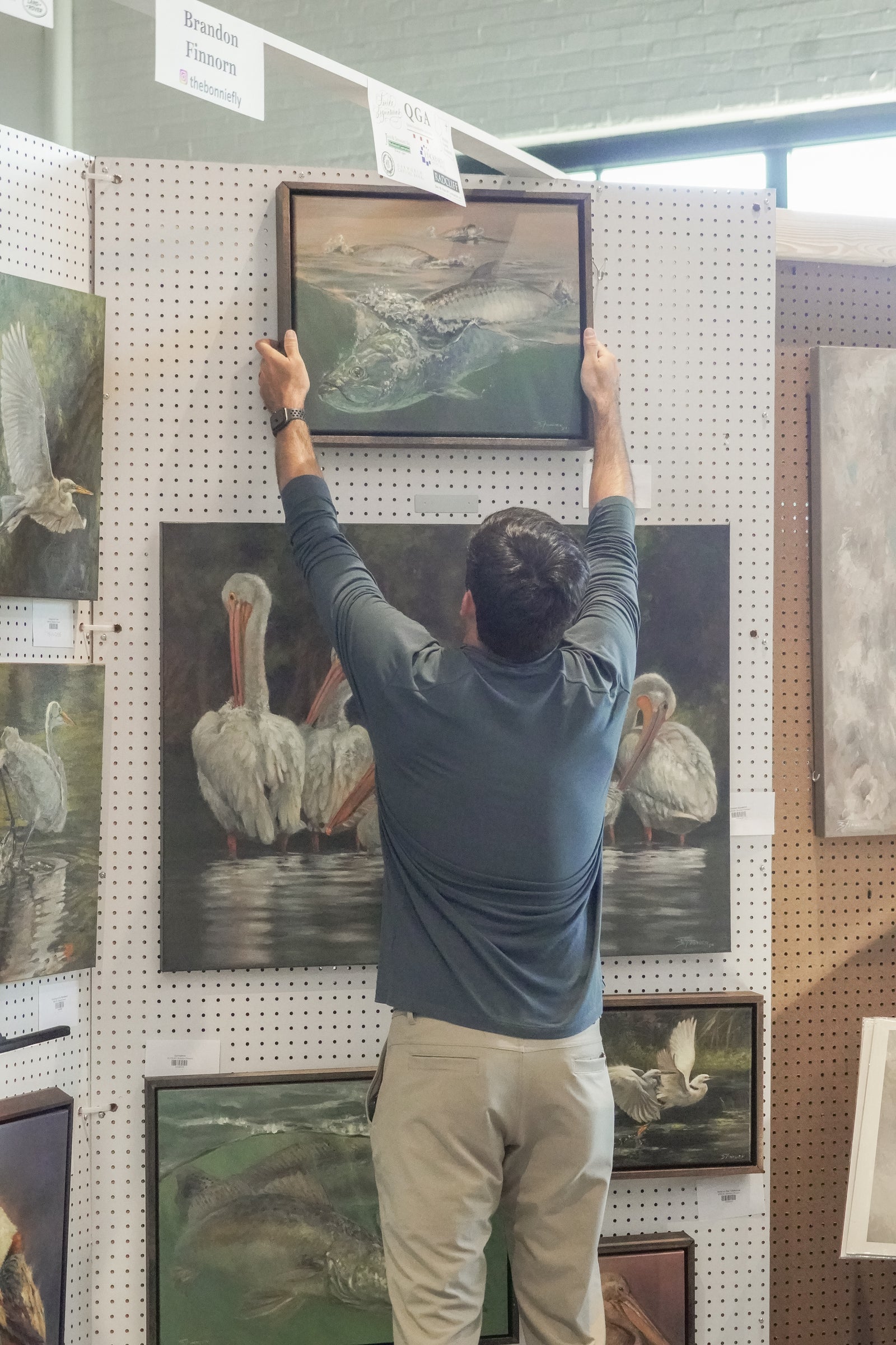 brandon finnorn at the loyola art show hanging his original fine art