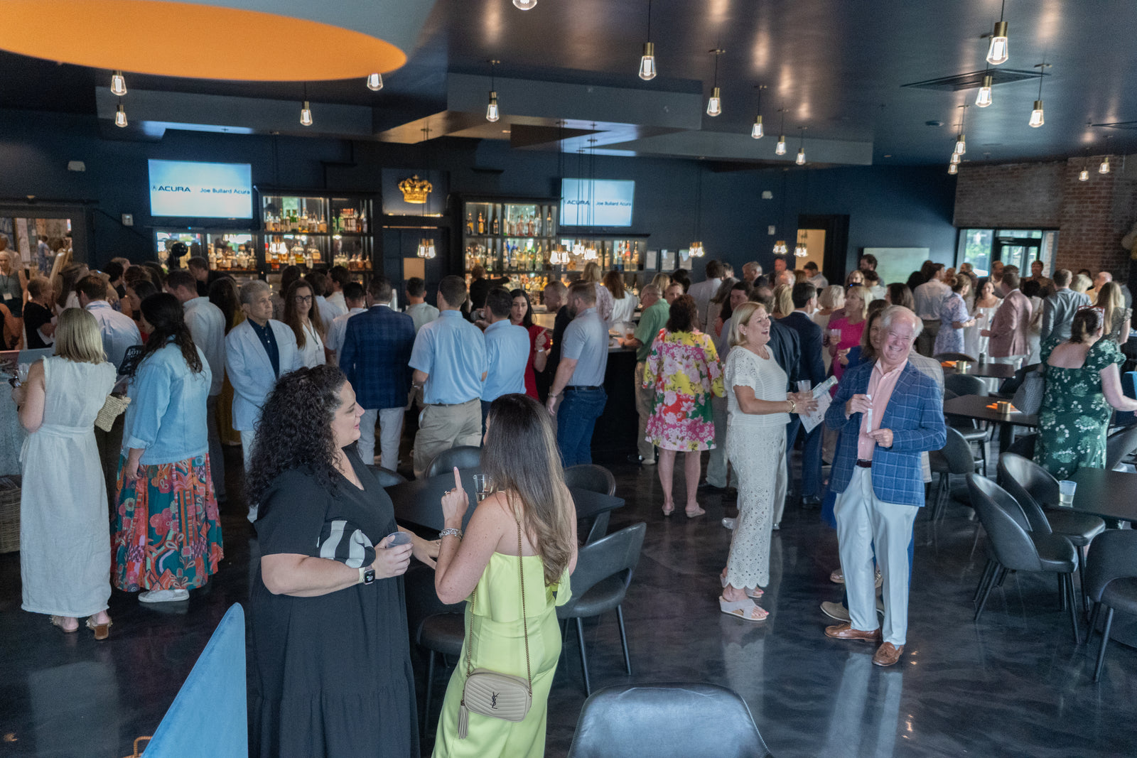 People socializing in a lively indoor setting during the friends of loyola preview event at crown hall