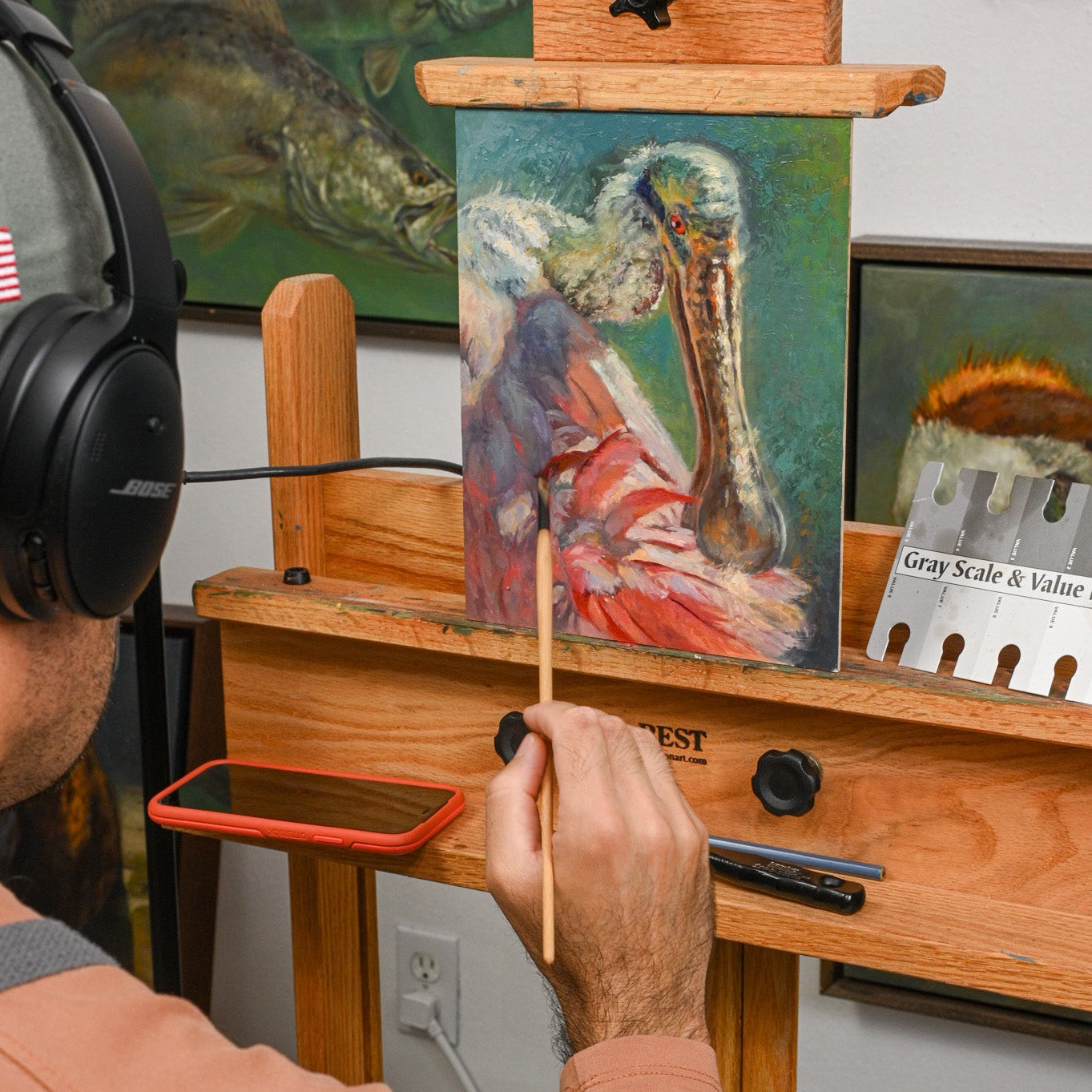 Brandon Finnorn painting a bird on an easel with various art supplies around